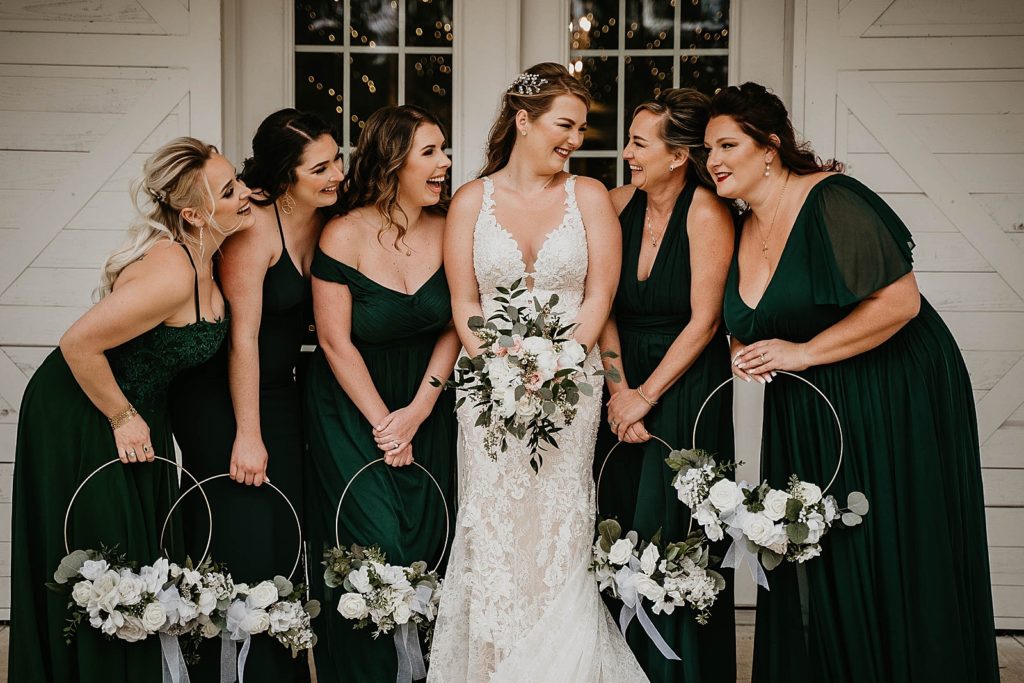 Bride with white bouquet standing with Bridesmaids holding circular bouquets Ever After Farms Wedding Photography captured by South Florida Wedding Photographer Krystal Capone Photography 