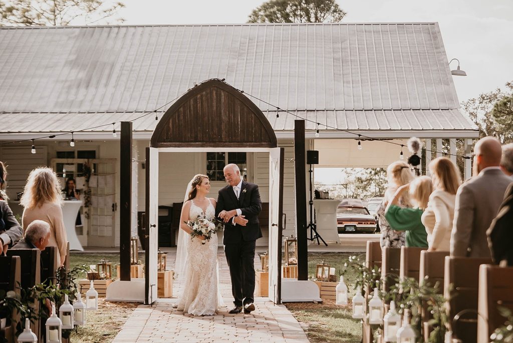 Bride entering Ceremony arm in arm with father Ever After Farms Wedding Photography captured by South Florida Wedding Photographer Krystal Capone Photography 