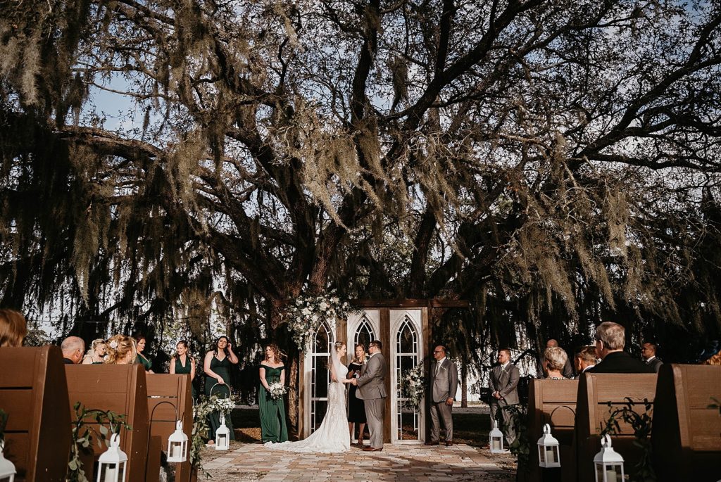 Wide shot of Bride and Groom holding hands during Homily Ever After Farms Wedding Photography captured by South Florida Wedding Photographer Krystal Capone Photography 