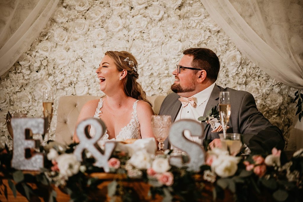 Bride and smiling and laughing at sweetheart table Ever After Farms Wedding Photography captured by South Florida Wedding Photographer Krystal Capone Photography 