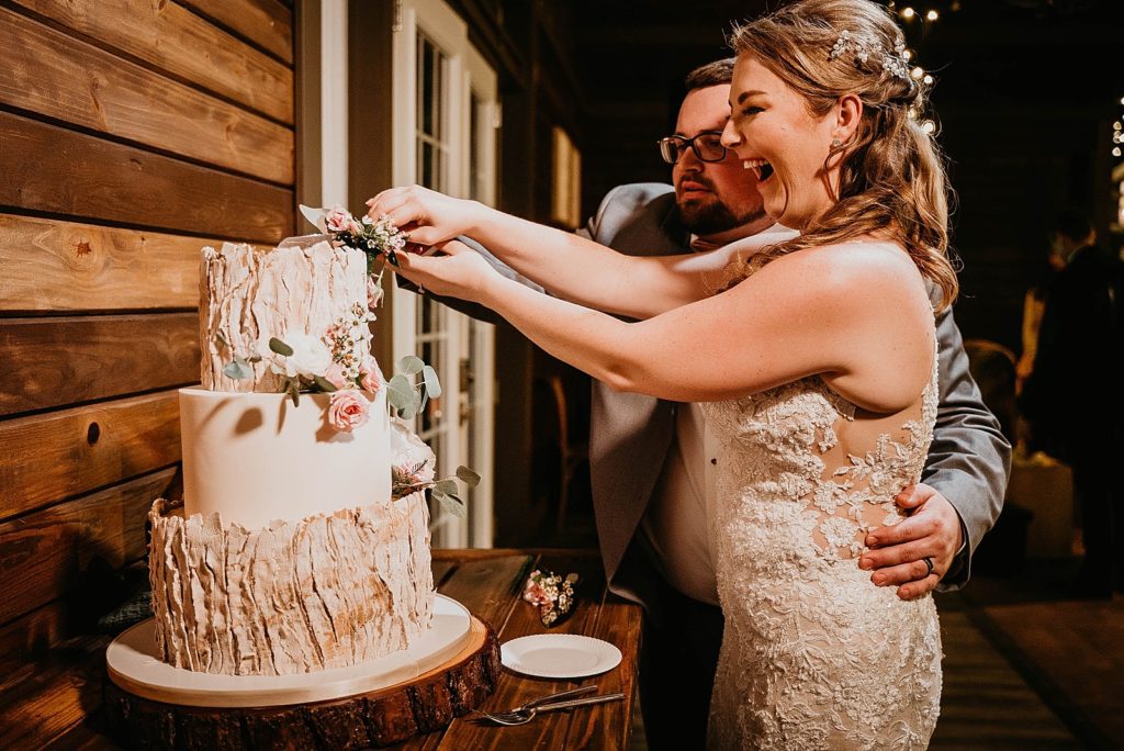 Bride and Groom cutting the wedding cake at Reception having fun Ever After Farms Wedding Photography captured by South Florida Wedding Photographer Krystal Capone Photography 