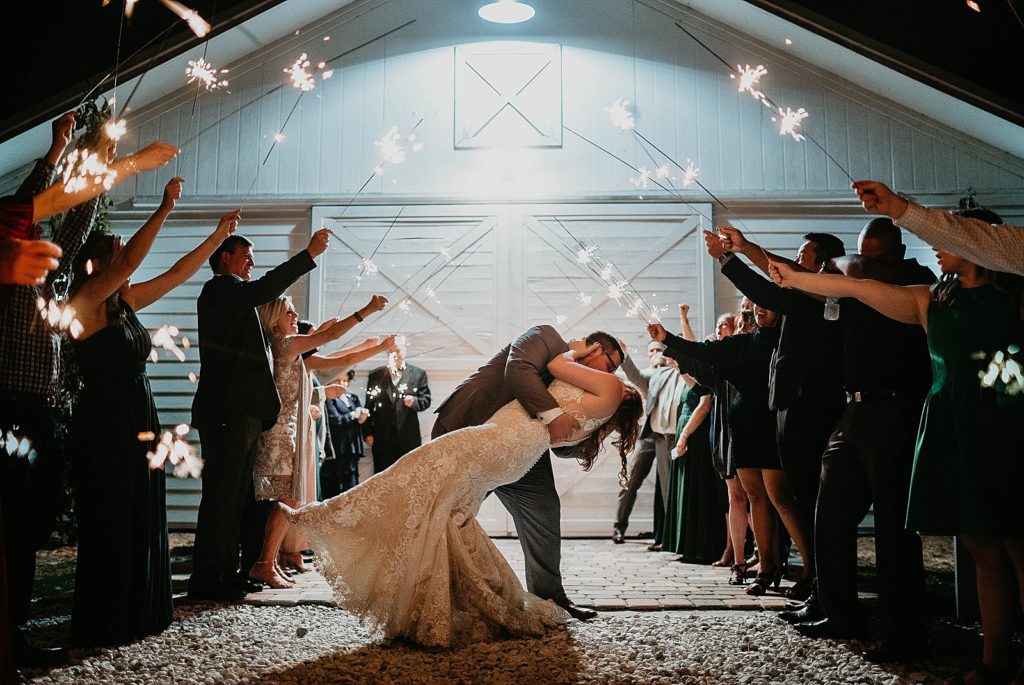 Bride and Groom dipping and kissing during nighttime sparkler exit Ever After Farms Wedding Photography captured by South Florida Wedding Photographer Krystal Capone Photography 