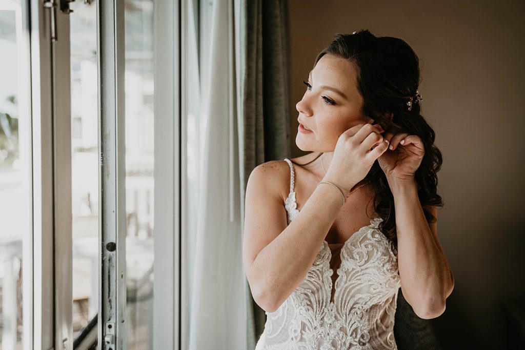 Bride getting ready putting on earrings Hawks Cay Resort Wedding Photography captured by South Florida Wedding Photographer Krystal Capone Photography 