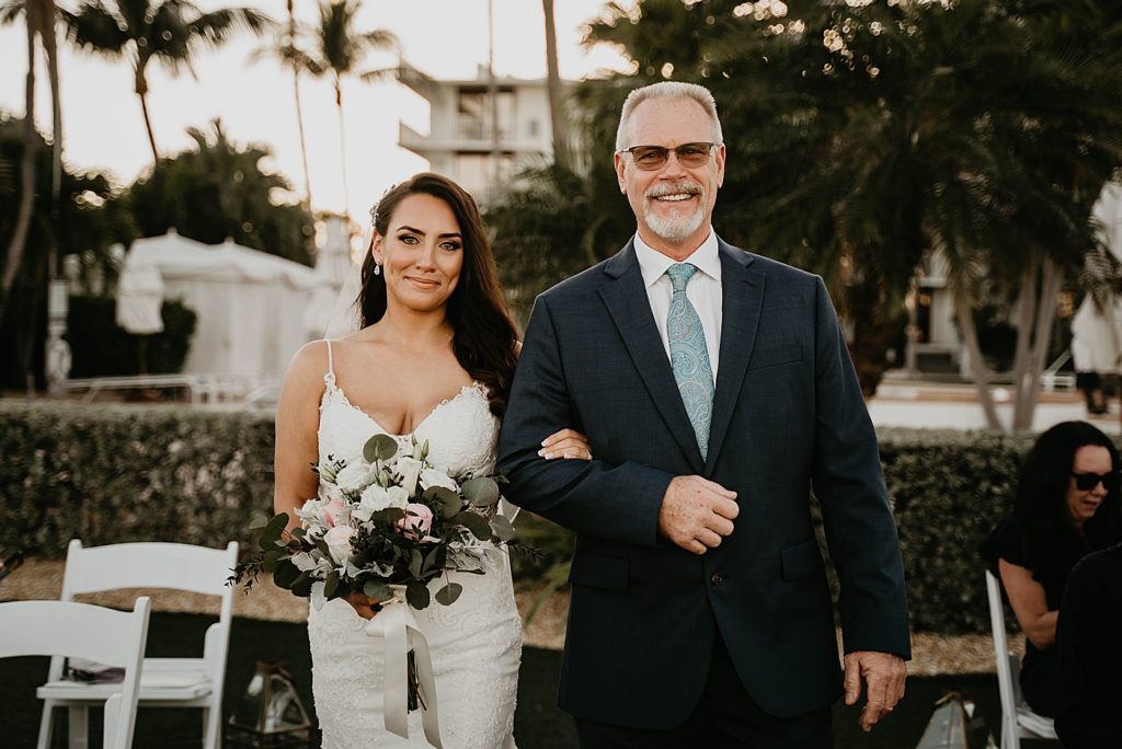 Father and Bride with light bouquet arm in arm entering Ceremony together Hawks Cay Resort Wedding Photography captured by South Florida Wedding Photographer Krystal Capone Photography