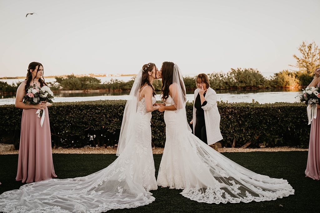 Just married Brides kissing in front of the water Ceremony Hawks Cay Resort Wedding Photography captured by South Florida Wedding Photographer Krystal Capone Photography