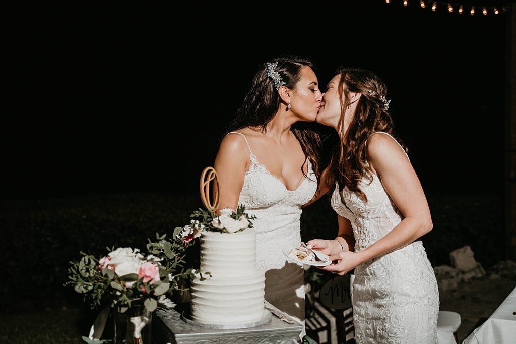 Brides kissing after nighttime cake cutting at Reception Hawks Cay Resort Wedding Photography captured by South Florida Wedding Photographer Krystal Capone Photography