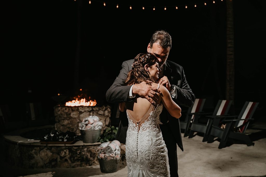 Father daughter nighttime dance with coal fire behind them Hawks Cay Resort Wedding Photography captured by South Florida Wedding Photographer Krystal Capone Photography