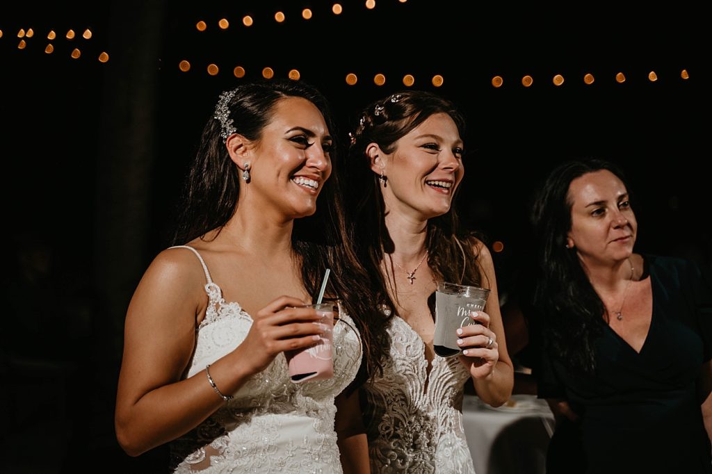 Brides standing together with drinks in hand Hawks Cay Resort Wedding Photography captured by South Florida Wedding Photographer Krystal Capone Photography
