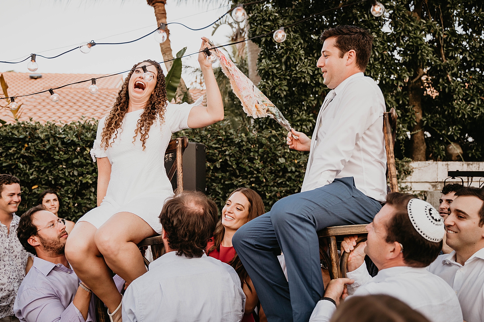 Bride and Groom sitting on chairs lifted up by friends and family for Hora Intimate South Florida Wedding Photography captured by South Florida Wedding Photographer Krystal Capone Photography 