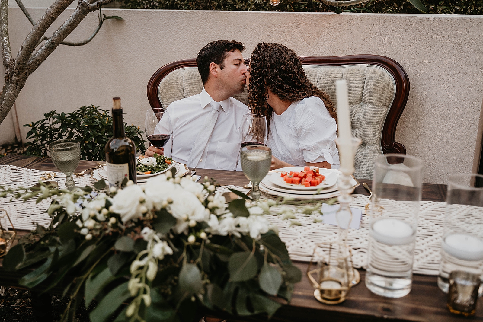 Bride and Groom kissing at sweetheart table with starter salad Intimate South Florida Wedding Photography captured by South Florida Wedding Photographer Krystal Capone Photography 