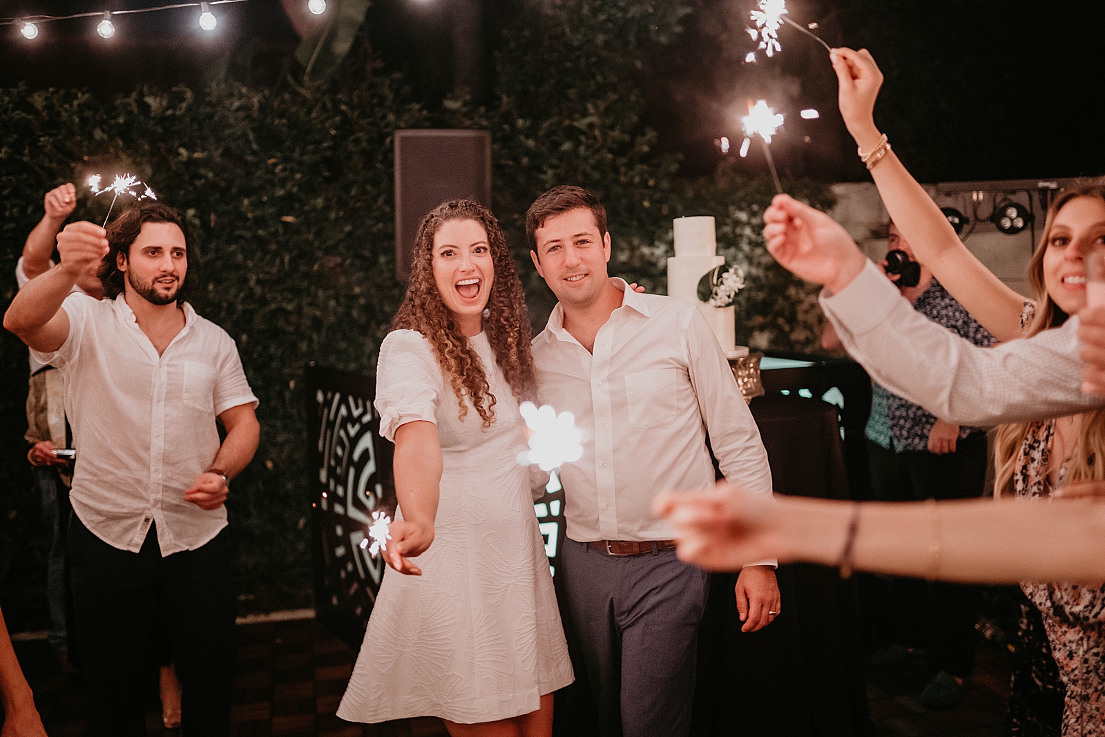 Bride and Groom posing with guests holding sparklers Intimate South Florida Wedding Photography captured by South Florida Wedding Photographer Krystal Capone Photography 