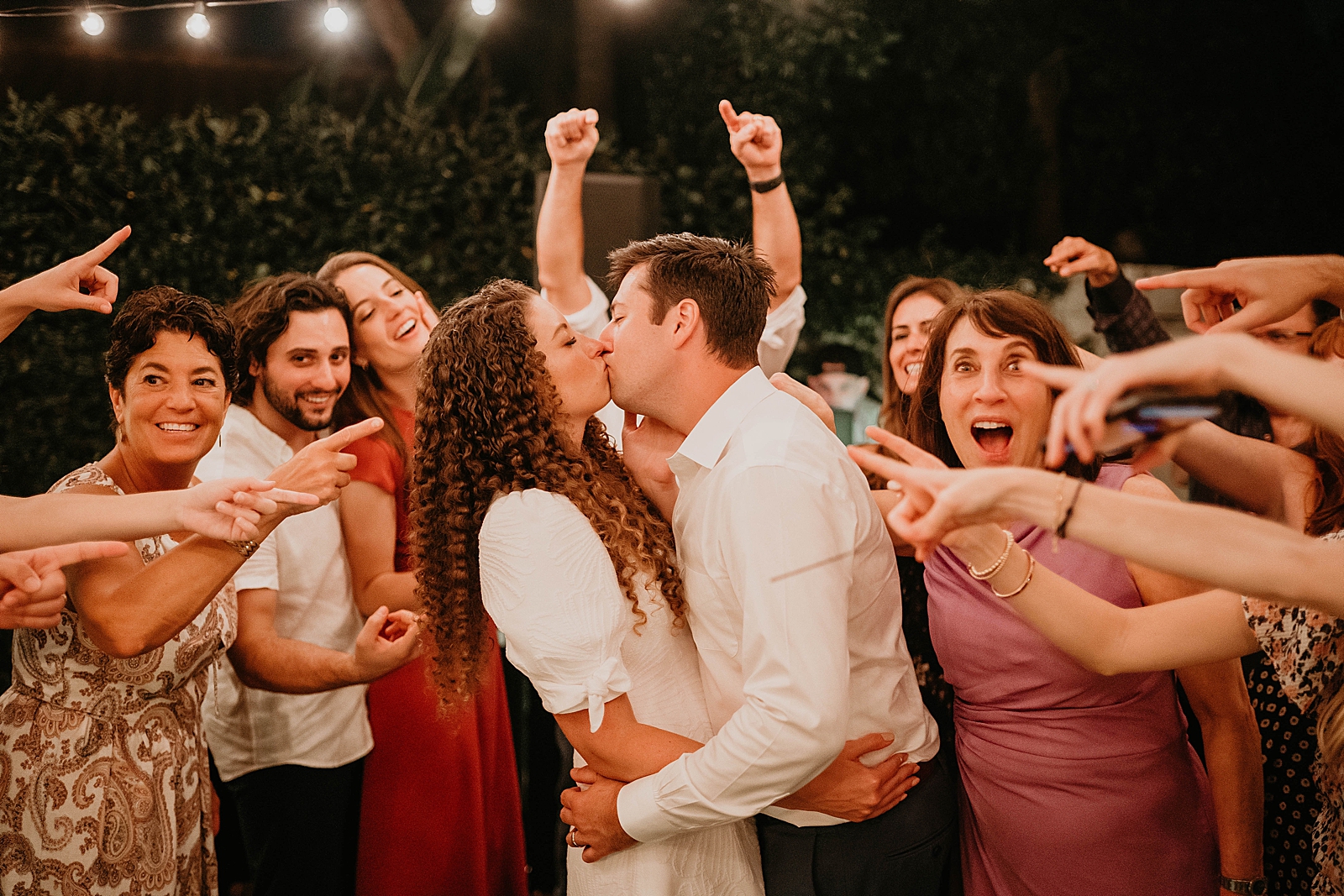 Bride and Groom kissing with attendees pointing at them Intimate South Florida Wedding Photography captured by South Florida Wedding Photographer Krystal Capone Photography 