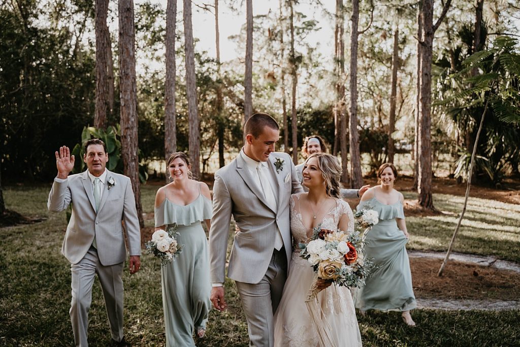 Groom and Groom holding each other with Wedding Party behind them Intimate South Florida Wedding Photography captured by South Florida Wedding Photographer Krystal Capone Photography 