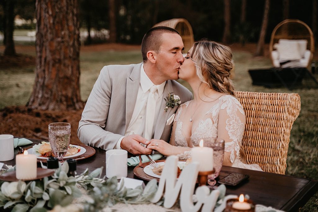 Bride and Groom kissing each other sitting at sweetheart table Intimate South Florida Wedding Photography captured by South Florida Wedding Photographer Krystal Capone Photography 