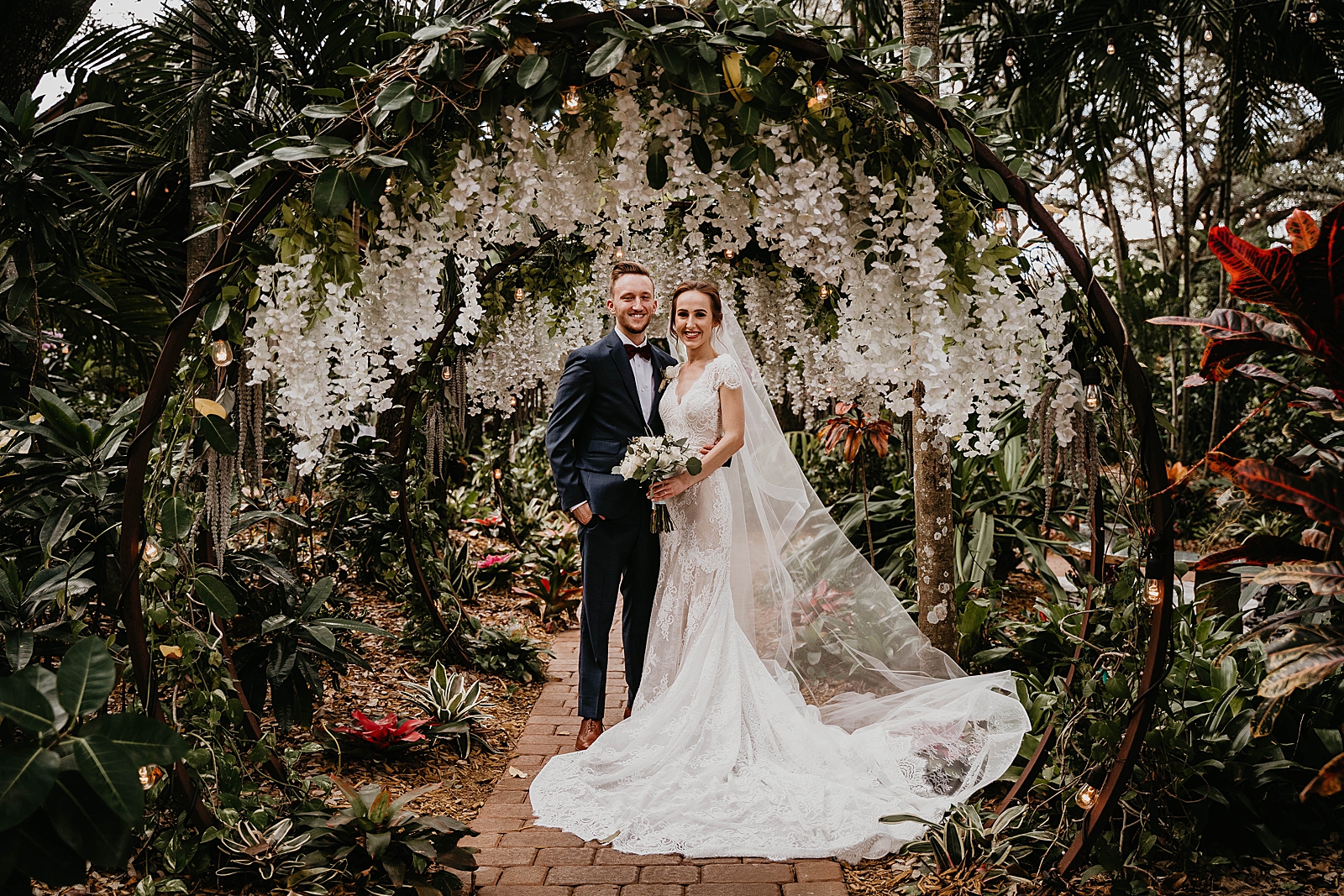Bride and Groom posing by botanical arch and garden Living Sculptures Sanctuary Wedding Photography captured by South Florida Wedding Photographer Krystal Capone Photography 