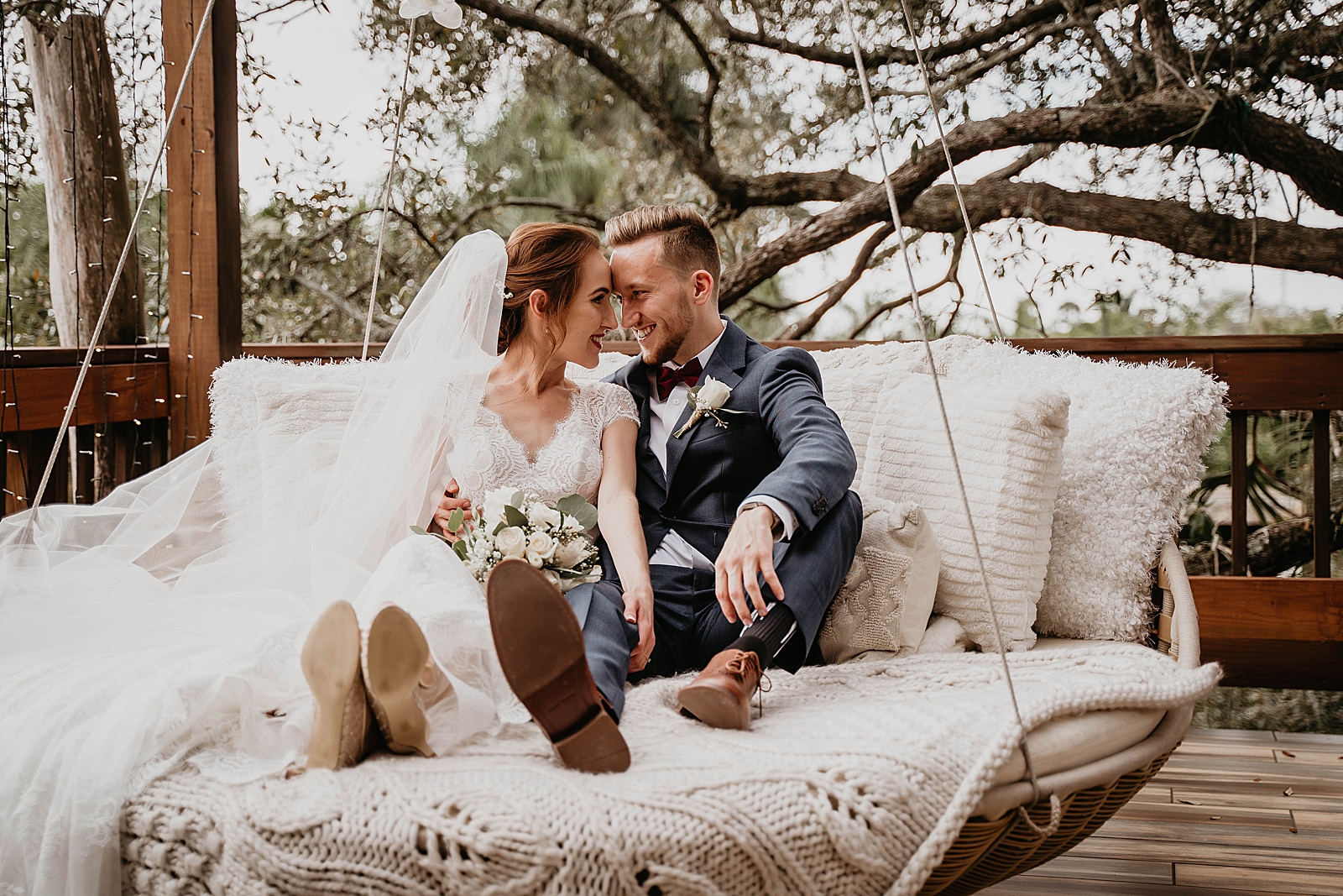 Bride and Groom sitting on swinging bed touching their foreheads together Living Sculptures Sanctuary Wedding Photography captured by South Florida Wedding Photographer Krystal Capone Photography 