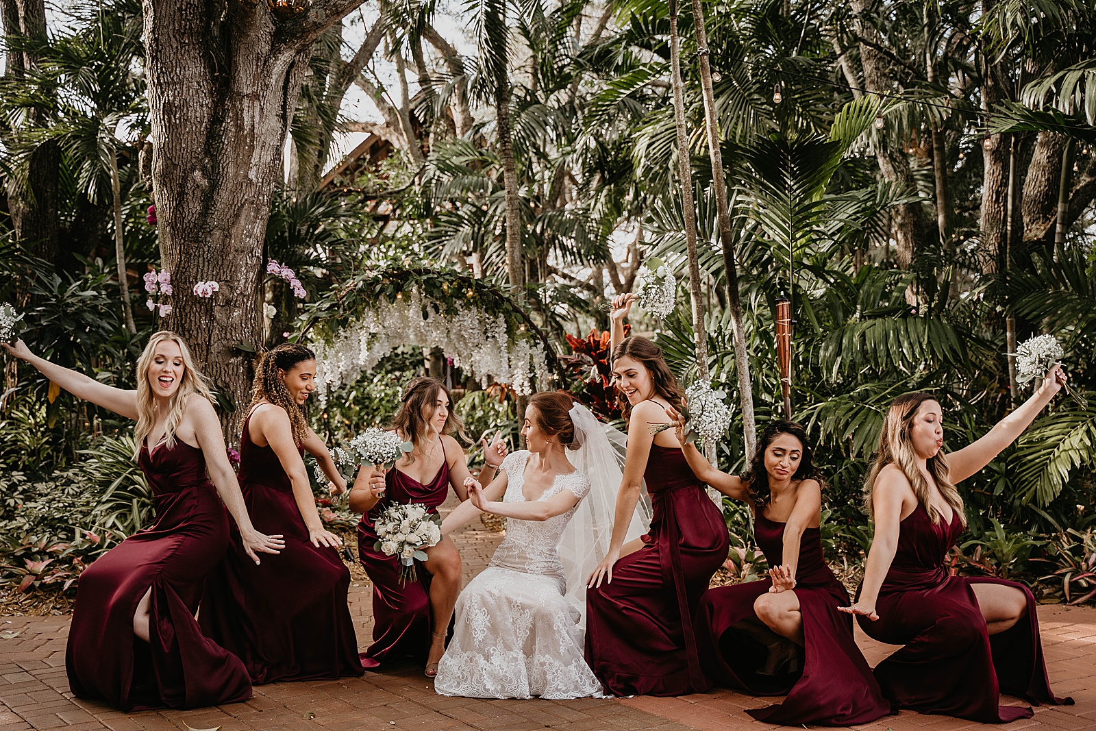 Bride and Bridesmaids doing fun poses in verdant garden Living Sculptures Sanctuary Wedding Photography captured by South Florida Wedding Photographer Krystal Capone Photography 