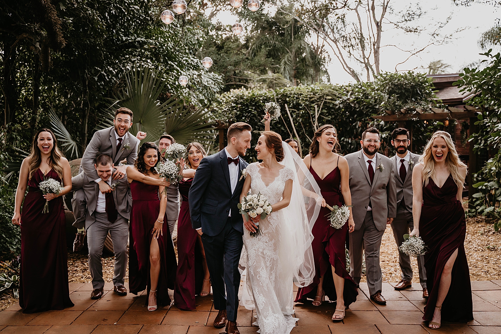Bride and Groom looking at each other with Bridal party behind them having fun Living Sculptures Sanctuary Wedding Photography captured by South Florida Wedding Photographer Krystal Capone Photography 