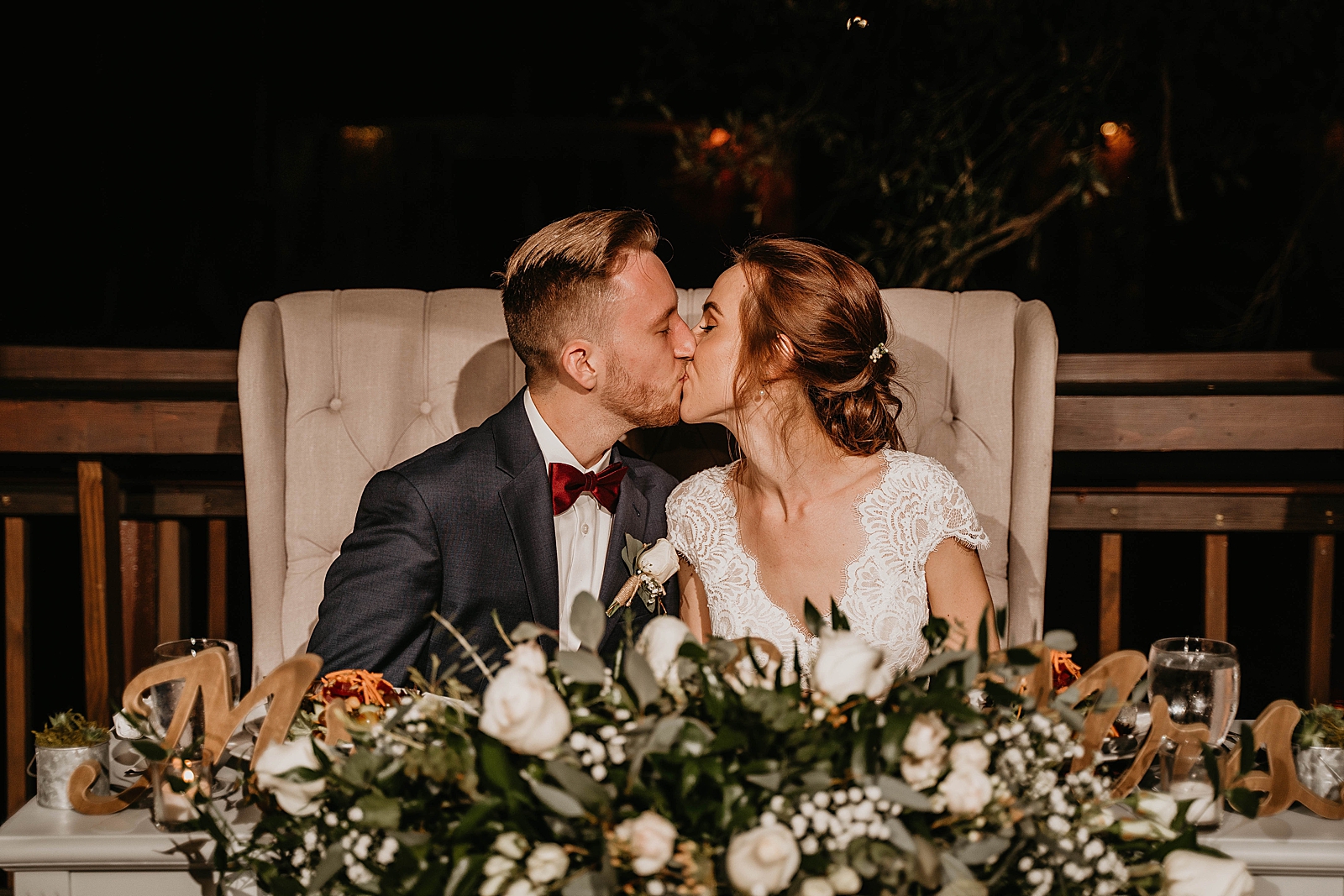 Bride and Groom kissing at sweetheart table Living Sculptures Sanctuary Wedding Photography captured by South Florida Wedding Photographer Krystal Capone Photography 