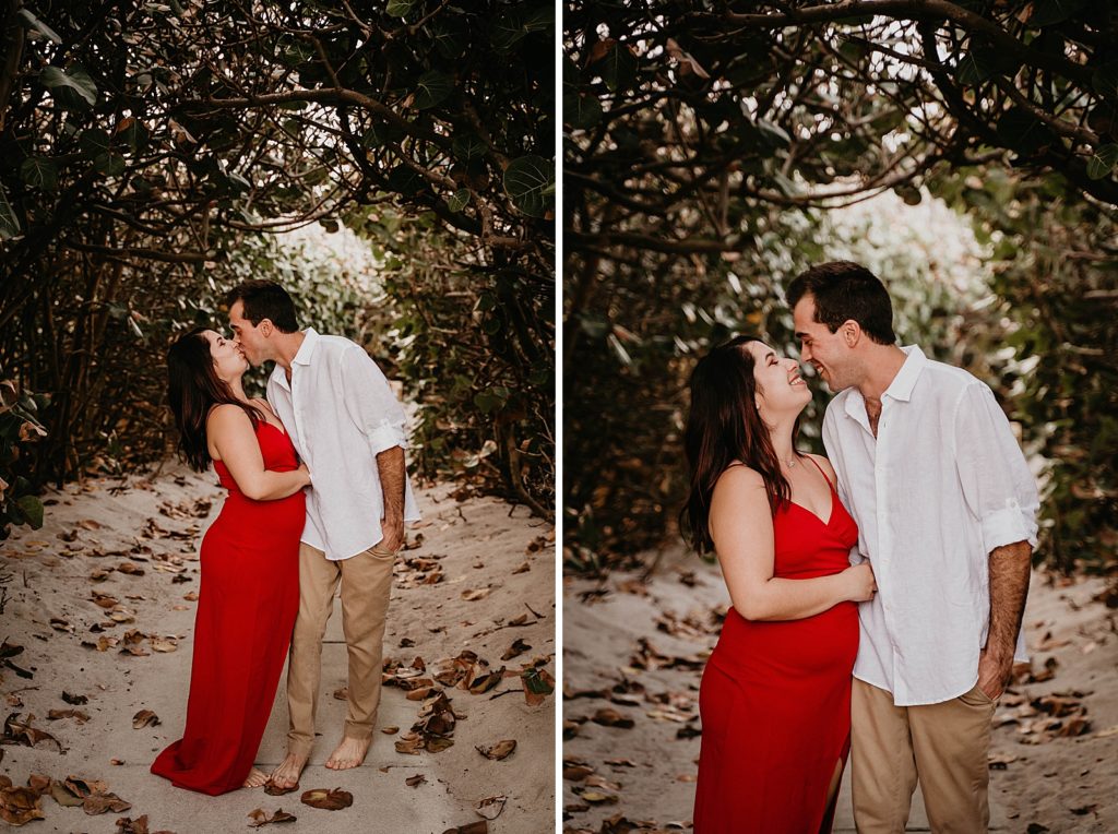 Couple kiss underneath the tree branches on the sand Palm Beach Engagement Photography captured by South Florida Engagement Photographer Krystal Capone Photography 