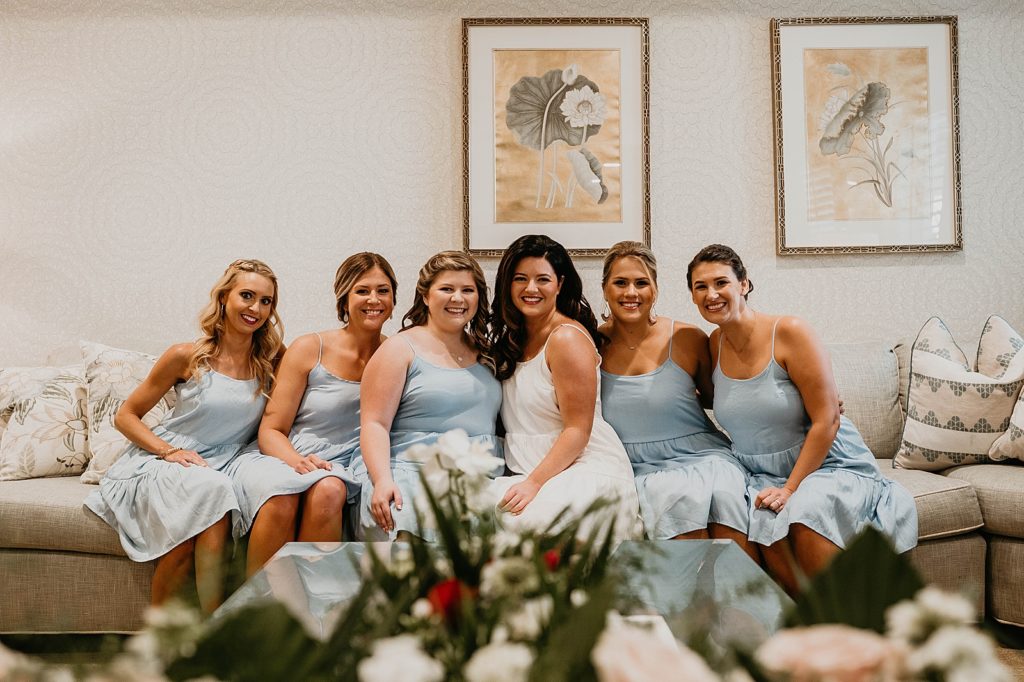 Bride and Bridesmaids sitting together getting ready Pelican Club Wedding Photography captured by South Florida Wedding Photographer Krystal Capone Photography 