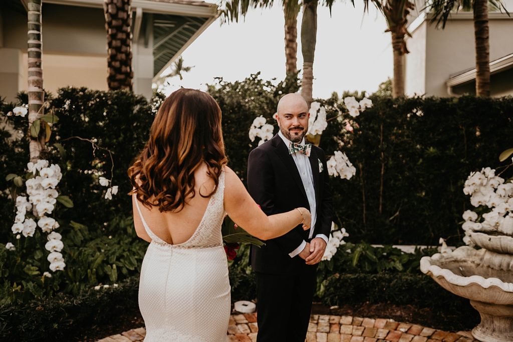 Groom turning around to see Bride for first look Pelican Club Wedding Photography captured by South Florida Wedding Photographer Krystal Capone Photography 