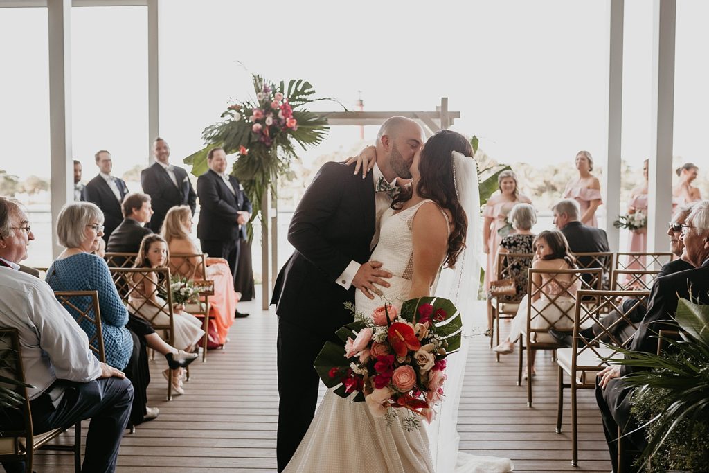 Bride and Groom kissing halfway through Ceremony exit Pelican Club Wedding Photography captured by South Florida Wedding Photographer Krystal Capone Photography 