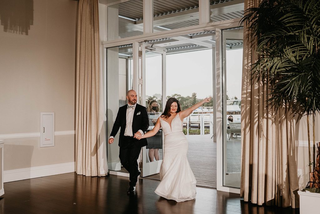 Bride and Groom entering Reception hand in hand Pelican Club Wedding Photography captured by South Florida Wedding Photographer Krystal Capone Photography 