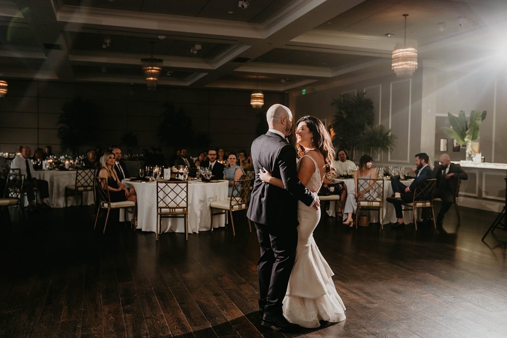 Bride and Groom First dance with guests sitting and watching at Reception tables Pelican Club Wedding Photography captured by South Florida Wedding Photographer Krystal Capone Photography 