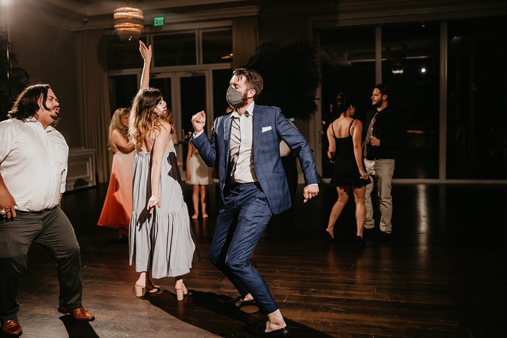 Fun dancing at Reception with masks on Pelican Club Wedding Photography captured by South Florida Wedding Photographer Krystal Capone Photography 