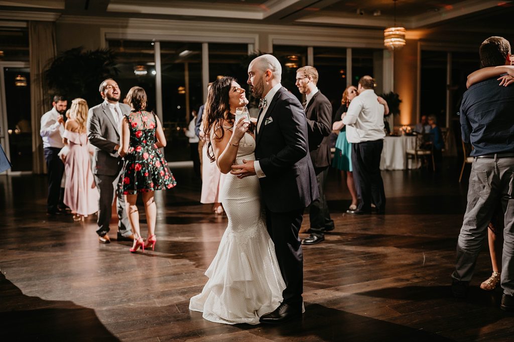 Bride and Groom dancing with drinks in hand Pelican Club Wedding Photography captured by South Florida Wedding Photographer Krystal Capone Photography 
