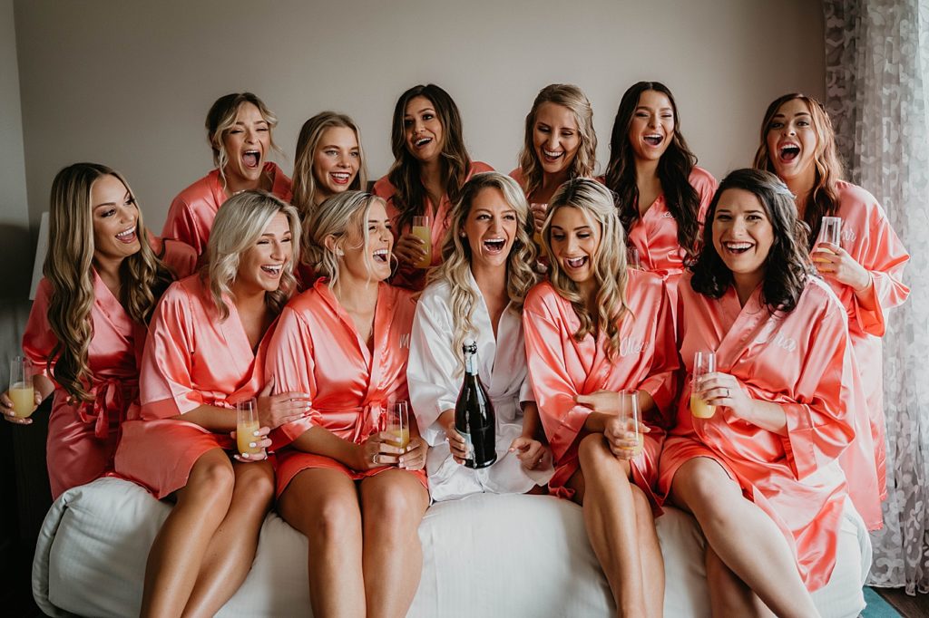Getting Ready Bride with Bridesmaids having a glass of wine in silk robes Pelican Club Wedding Photography captured by South Florida Wedding Photographer Krystal Capone Photography