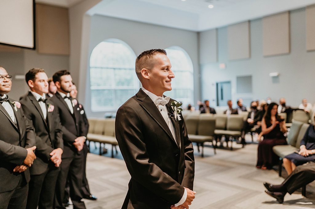 Groom standing awaiting Bride with Groomsmen behind him Ceremony Pelican Club Wedding Photography captured by South Florida Wedding Photographer Krystal Capone Photography