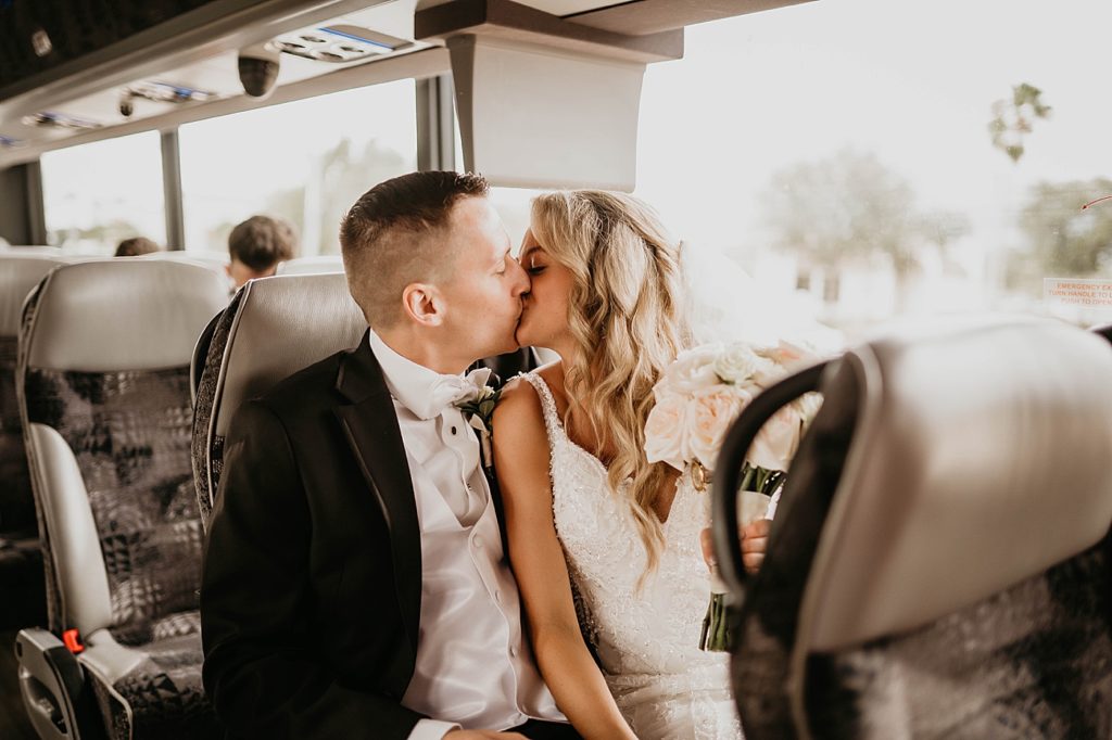 Bride and Groom kissing in the bus heading to the reception Pelican Club Wedding Photography captured by South Florida Wedding Photographer Krystal Capone Photography