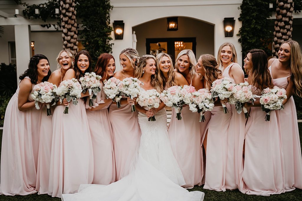 Bride and Bridesmaids standing together with light pink and white rose bouquet Pelican Club Wedding Photography captured by South Florida Wedding Photographer Krystal Capone Photography