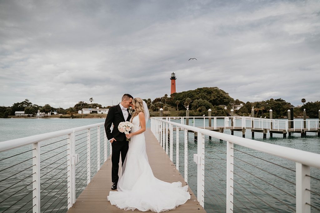 Bride and Groom nuzzling by the ocean Pelican Club Wedding Photography captured by South Florida Wedding Photographer Krystal Capone Photography