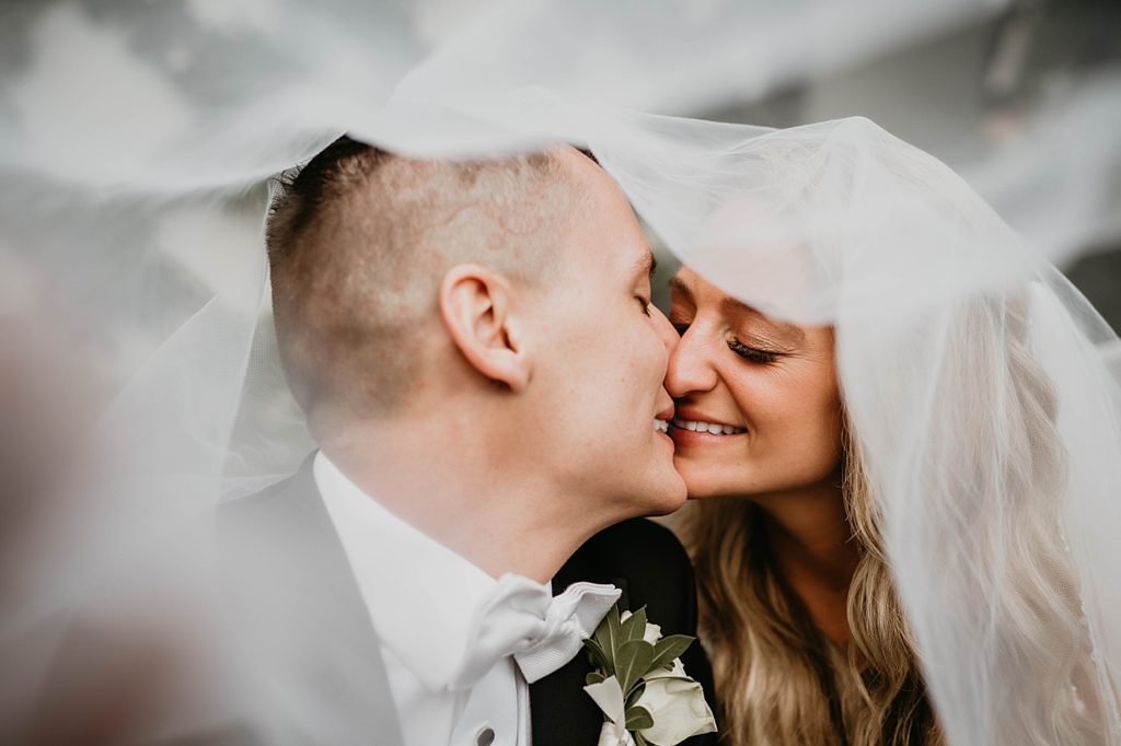 Bride and Groom kissing under the wedding veil Pelican Club Wedding Photography captured by South Florida Wedding Photographer Krystal Capone Photography