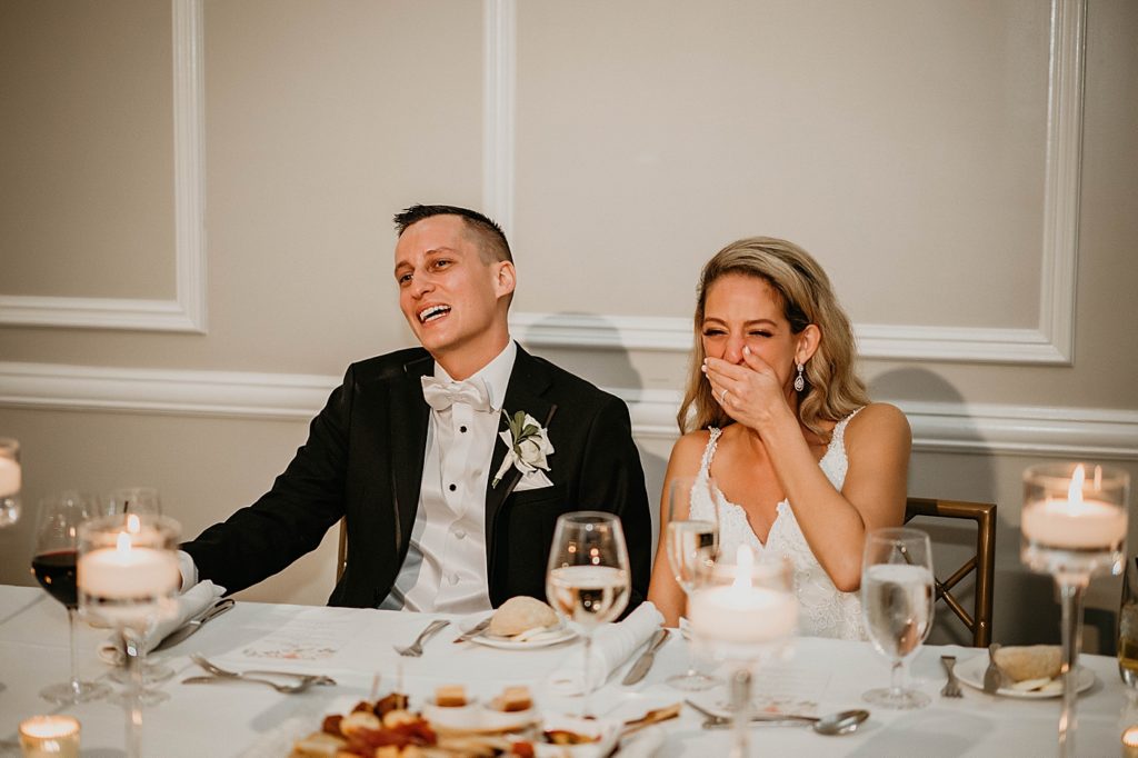 Bride and Groom laughing during speeches at Reception Pelican Club Wedding Photography captured by South Florida Wedding Photographer Krystal Capone Photography