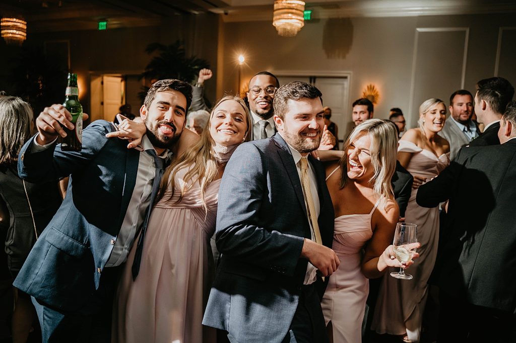 Dancing at the Reception with beers in hand Pelican Club Wedding Photography captured by South Florida Wedding Photographer Krystal Capone Photography