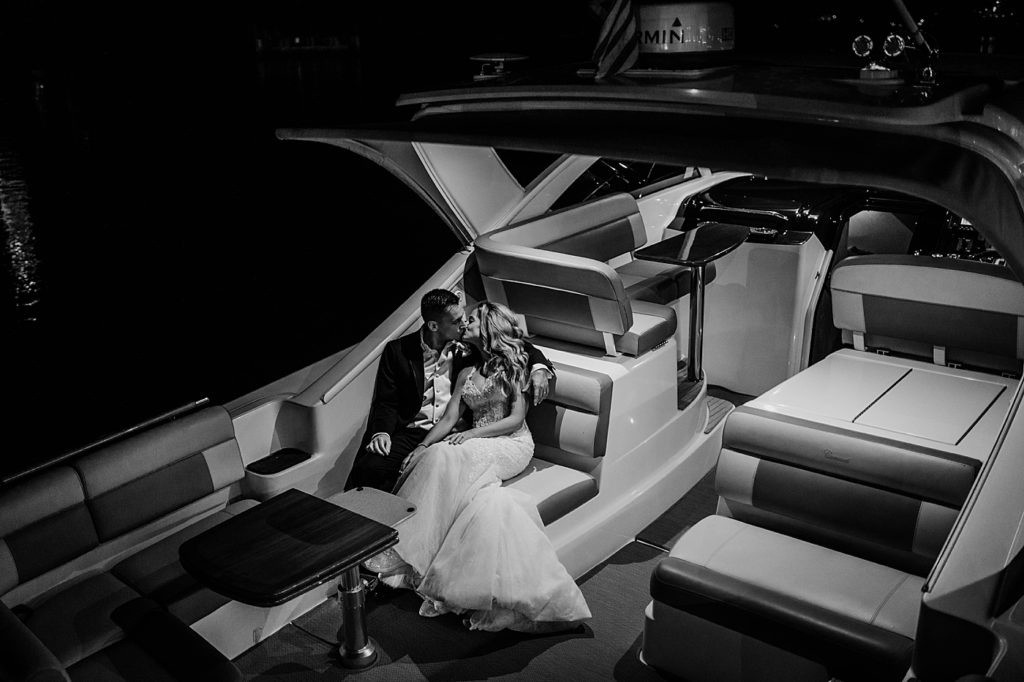 Bride and Groom kissing on boat B&W Pelican Club Wedding Photography captured by South Florida Wedding Photographer Krystal Capone Photography