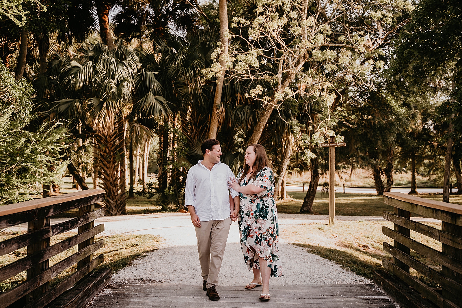 Couple holding each other strolling onto the bridge Riverbend Park Engagement Photography captured by South Florida Engagement Photographer Krystal Capone Photography 