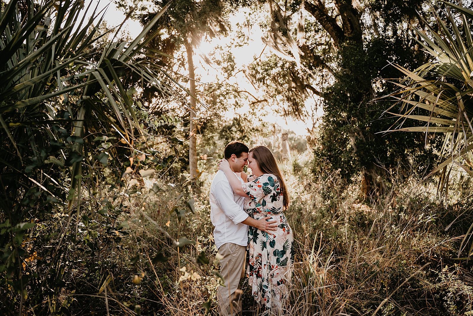 Couple holding each other close in tall grass Riverbend Park Engagement Photography captured by South Florida Engagement Photographer Krystal Capone Photography 