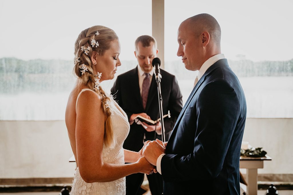 Bride and Groom holding hands during officiant prayer The Lake House Fort Pierce Wedding Photography captured by South Florida Wedding Photographer Krystal Capone Photography 