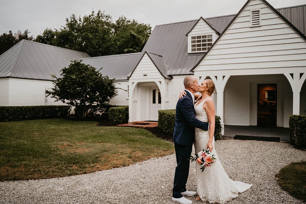 Bride and Groom kissing outside of house The Lake House Fort Pierce Wedding Photography captured by South Florida Wedding Photographer Krystal Capone Photography 