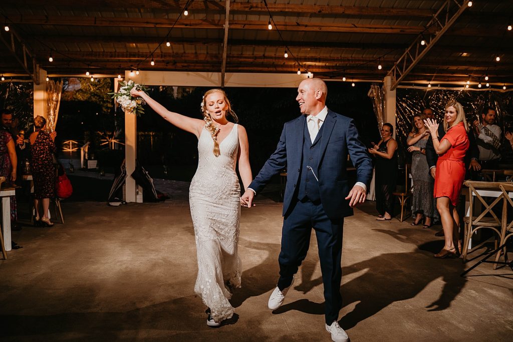 Bride and Groom excited entering nighttime Reception The Lake House Fort Pierce Wedding Photography captured by South Florida Wedding Photographer Krystal Capone Photography 