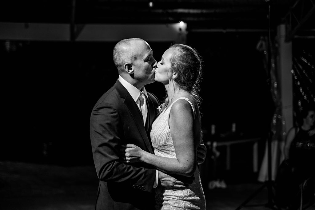 B&W Bride and Groom kissing during nighttime first dance The Lake House Fort Pierce Wedding Photography captured by South Florida Wedding Photographer Krystal Capone Photography 