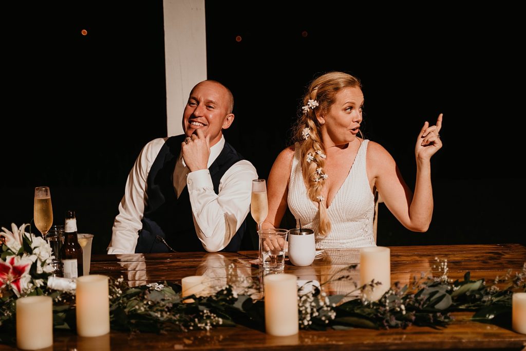 Bride and Groom having fun sitting at sweetheart table The Lake House Fort Pierce Wedding Photography captured by South Florida Wedding Photographer Krystal Capone Photography 