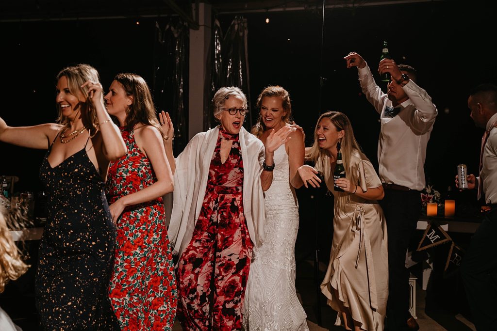 Women having fun dancing with drinks in hand The Lake House Fort Pierce Wedding Photography captured by South Florida Wedding Photographer Krystal Capone Photography 