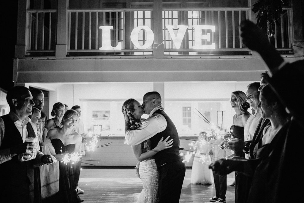 B&W Bride and Groom kissing during sparkler exit The Lake House Fort Pierce Wedding Photography captured by South Florida Wedding Photographer Krystal Capone Photography 