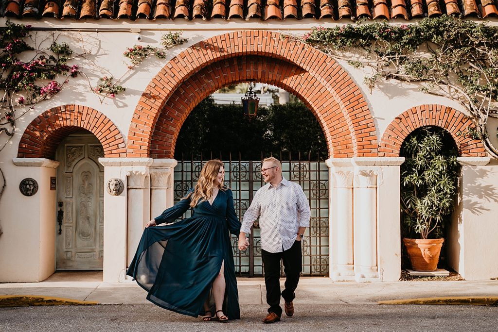 Couple holding hands walking onto the street together Worth Ave Palm Beach Engagement Photography captured by South Florida Engagement Photographer Krystal Capone Photography